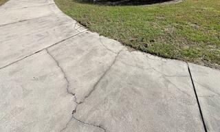 Soil settlement had created a lack of stability for the homeowner's concrete driveway, leading to significant damage.