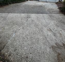 Several cracks had appeared across the surface of the homeowner's concrete driveway, caused by soil settlement and underlying tree roots that caused the slabs to heave.