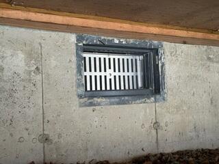 The crawl space vent was the only access point to the crawl space, but it was too small for a person to enter. Vents in crawl spaces are an older logic in crawl space design. Instead, crawl spaces should be treated as integral parts of the home. To ensure warmth and quality air, the homeowner sought a long-lasting solution. Modern methods for insulating and encapsulating crawl spaces include using vapor barriers and dehumidifiers. These innovative techniques help keep the space warm and moisture-free, improving overall home comfort and air quality.