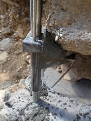 The foundation footing is secured to to the bracket to prevent further settlement.