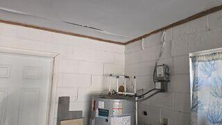 The homeowner grew concerned upon discovering stair-step cracks forming in the walls of their garage, along with ceiling cracks caused by foundation settlement.