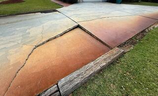 Significant soil erosion beneath the homeowner's concrete driveway had caused the slabs to break apart and settle.