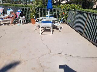 The settlement of the underlying soil had caused the concrete of this community's pool deck to shift and crack.