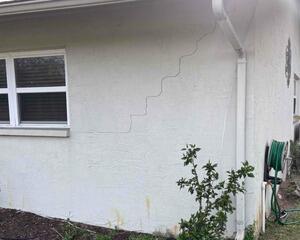 The homeowner noticed several cracks in the walls, including stair-step cracks, which are a common sign of foundation settling.