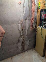 This is what the crack in Josh's basement foundation wall initially looked like when our Team arrived. You can see that it ran from the ceiling to the floor. Additionally, you can see where the previous owners attempted to repair the crack, only for it to start leaking water again.