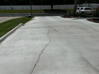 The homeowner's concrete driveway had experienced significant settlement caused by erosion of the underlying soil, resulting in widespread surface cracks and serious tripping hazards.