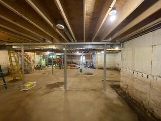 A wide view of the basement after our team secured the structure with SmartJack® support posts and heavy-duty steel beams. The result is a level, stable floor above and enhanced structural integrity.
