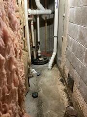 Although the existing sump pump in the basement remained operational, it lacked the capacity to effectively manage groundwater intrusion caused by the high water table. Due to its limited performance, a more comprehensive and robust waterproofing system was necessary to ensure consistent moisture control and protect the integrity of the finished basement.