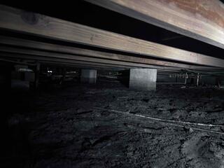 The floor joists in the building's crawl space had been noticeably sagging due to a lack of support from beneath them. Many of the original block piers had settled into the soil below, contributing to the structural instability and causing uneven flooring throughout the property.