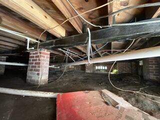 In this Jacksonville crawl space, the exposed soil and unprotected foundation supports created the perfect environment for excess moisture, high humidity, and potential wood rot. With no drainage system in place, water could easily collect underneath the home, leading to musty odors, mold growth, and structural concerns over time.