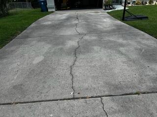 Due to the settlement of the underlying soil, the homeowner's driveway had become uneven and numerous cracks had spread throughout the surface.