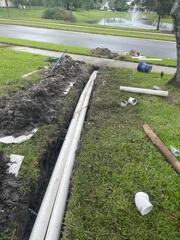 The LRE team excavates a trench to install the underground drainage pipe, designed to redirect rainwater away from the home.