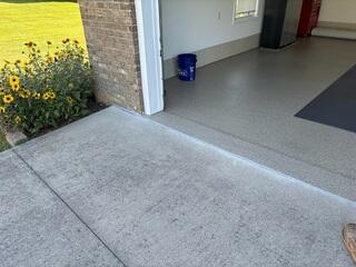 This photo shows the completed poly treatment at the garage entrance. The once uneven transition from driveway to garage is now smooth and sealed, eliminating trip hazards and protecting against further cracking.