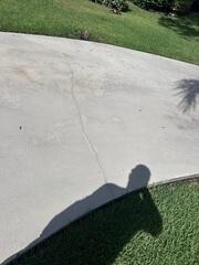 The settling of the soil beneath the driveway caused the concrete slabs to shift, leaving them uneven and cracked.