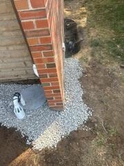 Underneath the rocks is the Sillplate Draintile™ System collects water off the walls to easily funnel it away from the foundation.