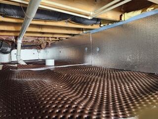 SilverGlo was placed on the walls to help insulate the space. Drainage Matting was laid down to move any standing water to the perimeter drains for removal.
