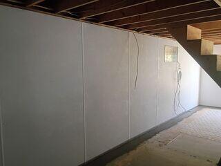 Our WaterGuard subfloor drains were installed around the entire perimeter of the basement to capture invading water. Weeping holes were drilled around the bottom of the foundation to invite water in. Our drains are installed on top of the footing to keep them out of the mud zone. WaterGuard also has openings in its wall flanges to help capture wall leaks the BrightWall drains down its backside.