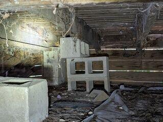 Upon inspection of the crawl space, the LRE Design Specialist discovered that many of the block piers supporting the home's floor joists had settled into the soil below.
