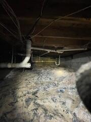 Crawl space during initial inspection. Dust, debris, and mud are visible.