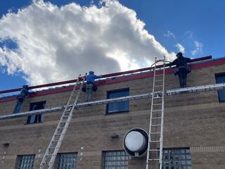 Team work Getting that section of gutter up the ladders