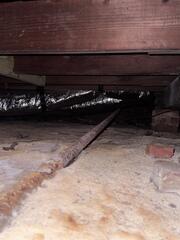 In this Jacksonville crawl space, you can see signs of aging and moisture damage beneath the home. The rusted support beam and exposed soil indicate long-term humidity and structural strain both early warning signs of floor instability. These conditions highlight why a full crawl space repair and stabilization system was needed to restore a dry, secure foundation environment.