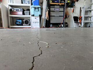 The concrete slab of the homeowner's garage had developed large cracks over time due to the settlement of the underlying soil.