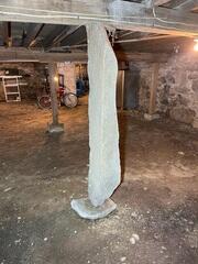 The existing basement support posts lacked sufficient load-bearing capacity, causing the floor system above to experience structural deflection and begin to sag.