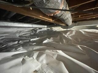 A view of the crawl space after encapsulation with CleanSpace®. The bright white liner seals the ground and walls, keeping out moisture and odors while helping control humidity throughout the home.