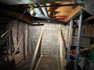 Close-up of the bulging block wall showing the homeowner's temporary 2x4 support.