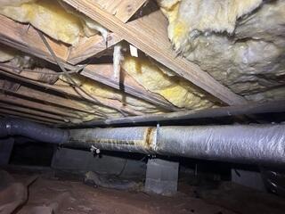 In this Stoneville, NC crawl space, the homeowner was dealing with the early warning signs of moisture problems. The insulation is sagging and falling out of place, showing that it has absorbed moisture from the crawl space air. When insulation gets wet, it loses effectiveness, grows mold, and can contribute to higher energy bills and uncomfortable floors above. The exposed dirt also allows humidity and musty odors to rise into the home a clear indication that this crawl space needed a controlled, sealed environment.