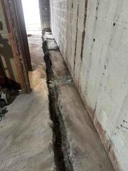 For houses with a monolithic foundation, we install our DryTrak System to avoid having to jackhammering the thick concrete slab directly against the wall. Instead, the jackhammering is done away from the wall to install the lines that connect to the DryTrak System.