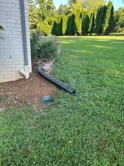 Water escapes from the IceGuard® fitting only when the discharge line becomes clogged. Otherwise, water flows past the slotted openings into the drain pipe. LawnScape™ is a pipe buried from the downspout to a special LawnScape™ outlet that lets the water out onto the surface while camouflaging the end of the pipe. The lid comes off for easy cleaning. LawnScape™ is best used for downspout extensions over 8' long.