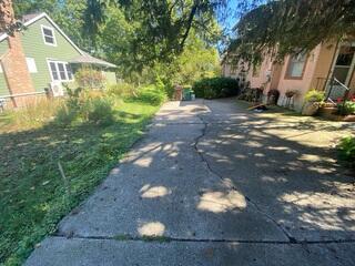The driveway had multiple cracks and significant settlement, causing uneven slabs and drainage issues. These conditions prompted the homeowner to seek a long-lasting concrete solution.