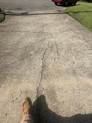 During inspection, the design specialist found cracked concrete across the driveway.