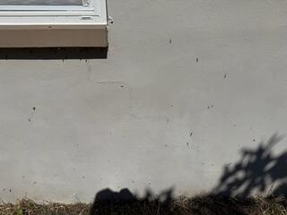 Stair-step pattern wall cracks had developed within the exterior walls of the home, a common sign of foundation settlement.