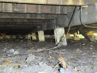 The LRE Design Specialist's inspection revealed that many of the original block piers in the crawl space had settled, compromising the stability of the floor joists.