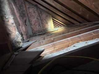 The R-13 fiberglass on the rafters of this knee wall were not high-quality enough to protect against air infiltration.