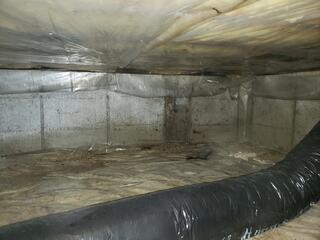 Before: Damp, Exposed Crawl Space