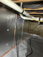 So we removed all the debris & old insulation out of the crawl space, leveled the ground for proper draining and installed a drainage matting. A drainage matting is a dimpled plastic mat that allows all excess moisture to work its way over to the sump pump. Next we installed a vapor barrier, which is is a heavy-duty, 20-mil 7-ply sandwich of high and low-density polyethylene with a polyester-cord reinforcement. By encapsulating the crawl space & installing the vapor barrier over the foundation walls and floor will create a continuous air and moisture barrier. The vapor barrier is also...