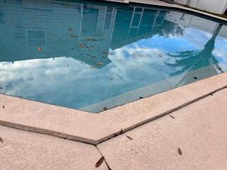 The home's concrete pool deck had settled significantly, causing the slabs to sink and create numerous tripping hazards.