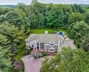 A full drone view of this beautiful home in Bedford, NY, before the upgrade, ready to get gutters built to match the look and handle the flow.