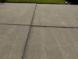 The concrete slabs in the homeowner's driveway had settled, causing them to become uneven and creating a significant tripping hazard.