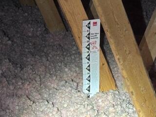 The old attic insulation shows a low R-value, allowing conditioned air to escape into the attic. This will reduce the homes energy efficiency for the customer.