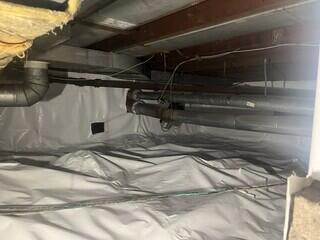 Vapor barrier sealed over crawl space floor and wall