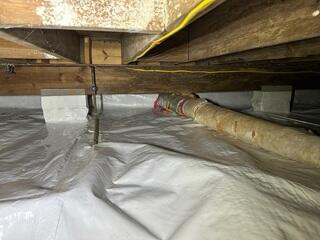 We wrap the piers with Wallie to help reduce the amount of condensation that can enter through the porous concrete blocks.