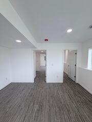 Looking from the living space to the doorways the left door is a bathroom in the middle that leads to a bedroom area and the right door leads to a closet and that also leads to the bedroom area