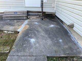 This section of concrete near a side entrance had settled and become uneven. Our crew injected polyurethane foam through small holes in the slab, allowing the material to expand beneath the concrete, fill voids, and help lift the surface back into position.