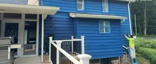 High-reach exterior siding painting performed with safety and expert detail.