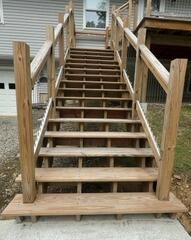 Untreated exterior wooden staircase showing severe graying and moisture exposure prior to cleaning and sealing.
