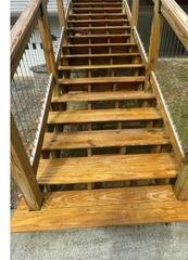 Fully restored and sealed wooden stairs highlighting rich natural wood grain and superior weather protection.